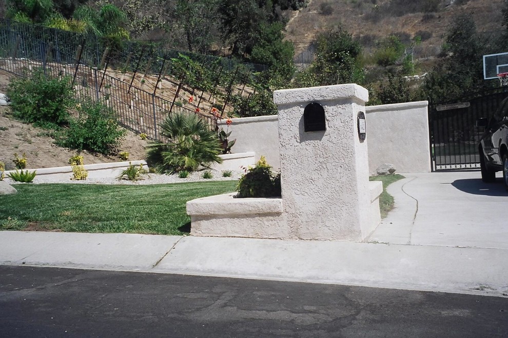 Inspiration for a mid-sized traditional front yard full sun xeriscape for summer in Santa Barbara with a retaining wall and concrete pavers.