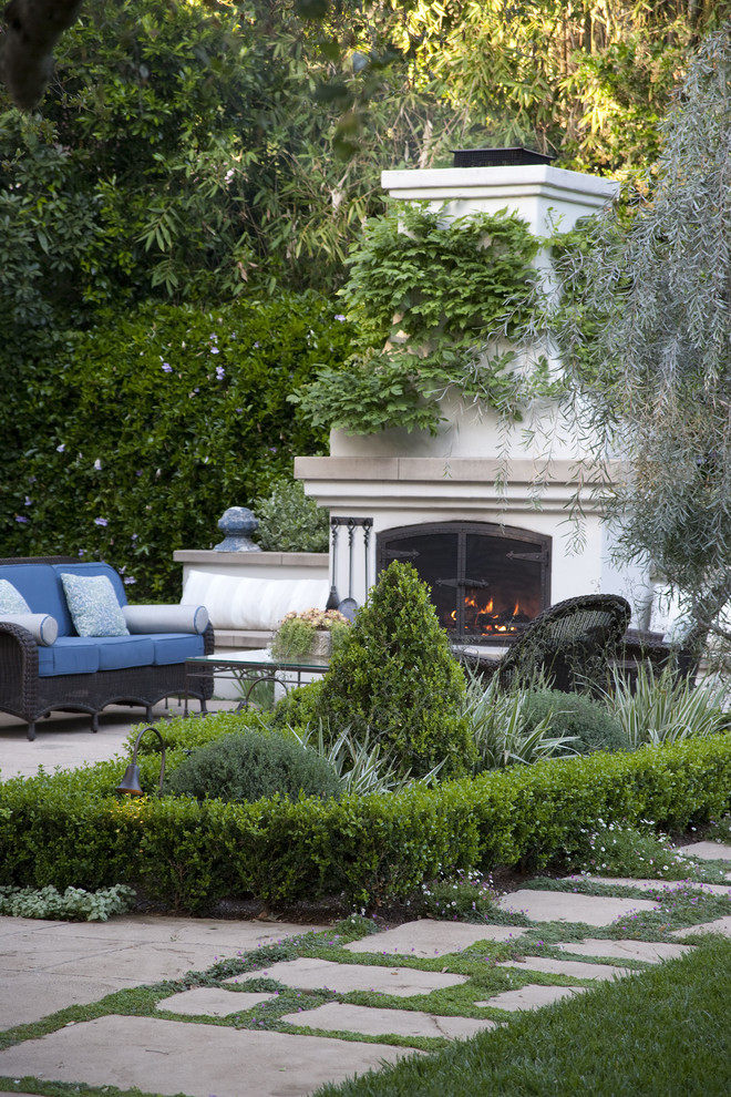 Large traditional backyard formal garden in Los Angeles with a fire feature.