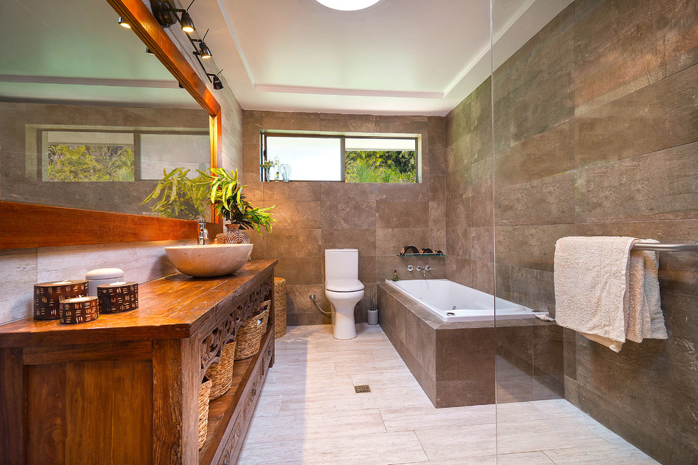 This is an example of an asian bathroom in Gold Coast - Tweed with an alcove tub, brown walls, a vessel sink, an open shower and brown benchtops.
