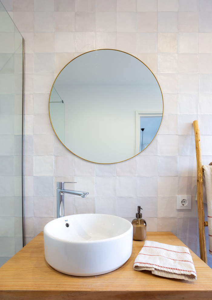 This is an example of a mid-sized mediterranean master bathroom in Barcelona with open cabinets, white cabinets, an alcove shower, a one-piece toilet, multi-coloured tile, ceramic tile, multi-coloured walls, ceramic floors, a vessel sink, wood benchtops, multi-coloured floor, an open shower, brown benchtops and a floating vanity.