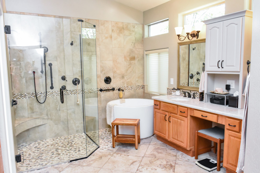Large modern master bathroom in Phoenix with raised-panel cabinets, brown cabinets, a japanese tub, a corner shower, a two-piece toilet, beige tile, ceramic tile, beige walls, porcelain floors, a drop-in sink, quartzite benchtops, beige floor and a hinged shower door.