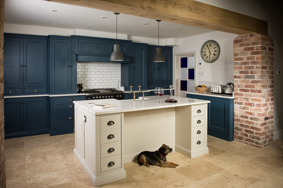 Mid-sized traditional single-wall kitchen in Other with a farmhouse sink, quartz benchtops, white splashback, subway tile splashback, black appliances, limestone floors and with island.