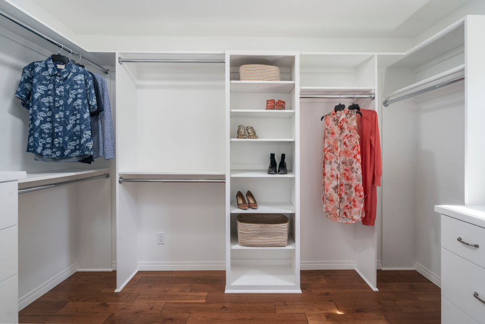 Mid-sized transitional gender-neutral walk-in wardrobe in Los Angeles with shaker cabinets, white cabinets, medium hardwood floors and brown floor.