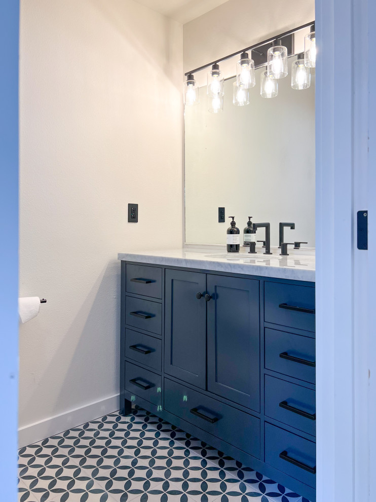Example of a small danish master gray tile and ceramic tile ceramic tile, blue floor and single-sink double shower design in Seattle with recessed-panel cabinets, blue cabinets, a bidet, beige walls, an integrated sink, marble countertops, a hinged shower door, white countertops and a freestanding vanity