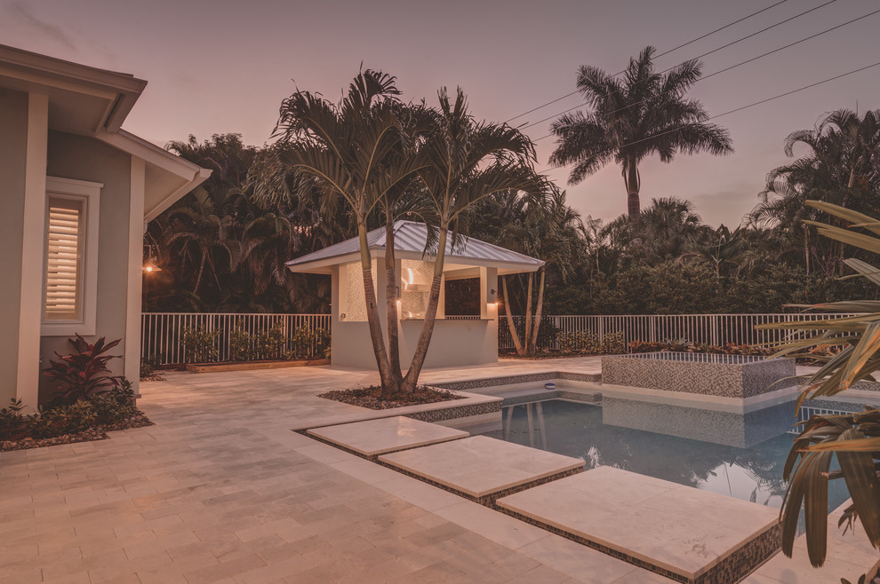 Inspiration for a large transitional backyard custom-shaped natural pool in Miami with a hot tub and natural stone pavers.