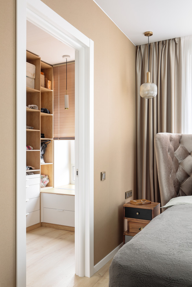 Diseño de dormitorio escandinavo de tamaño medio con paredes beige, suelo de madera en tonos medios y suelo marrón