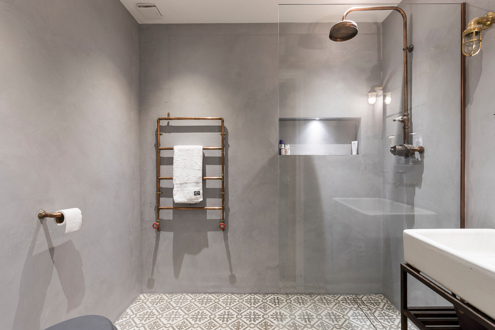 Inspiration for a mid-sized industrial kids bathroom in London with an open shower, glass tile, grey walls, cement tiles and a vessel sink.