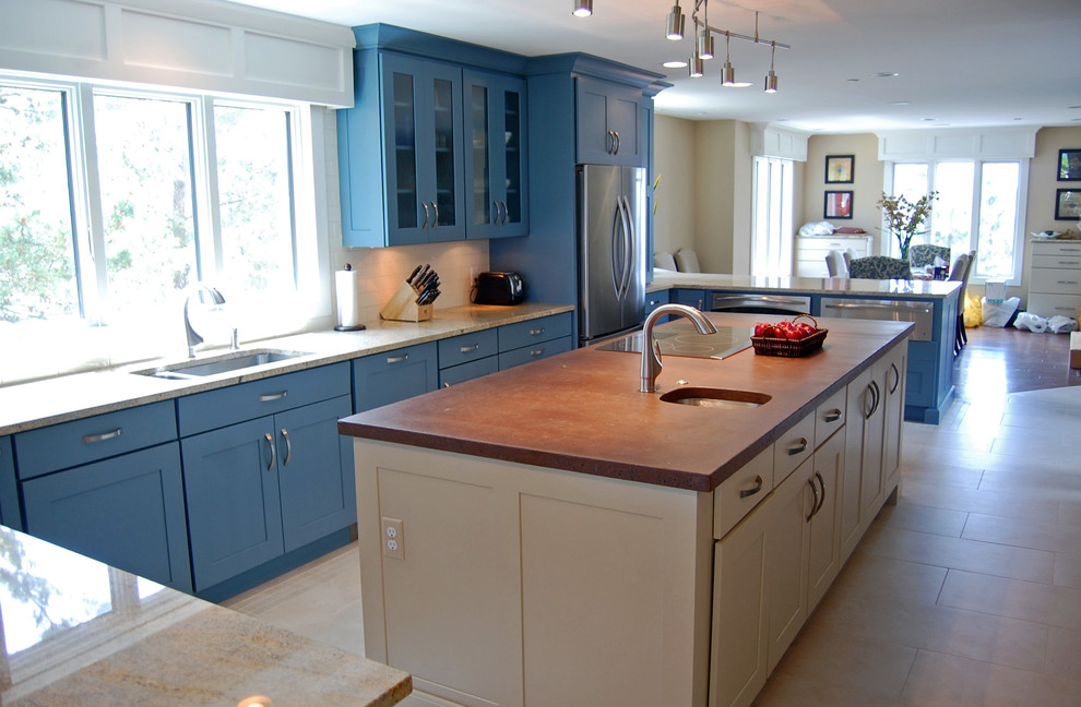 Photo of a large beach style u-shaped eat-in kitchen in Baltimore with an undermount sink, shaker cabinets, stainless steel appliances, ceramic floors, with island, blue cabinets, granite benchtops, white splashback and ceramic splashback.