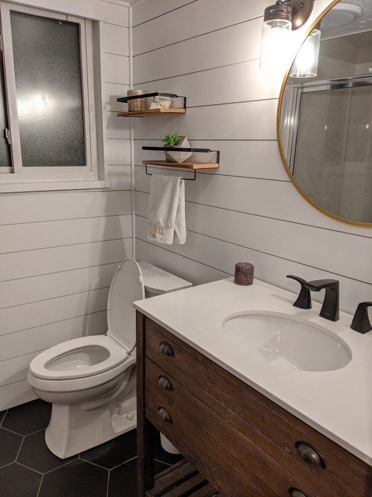 Design ideas for a mid-sized country 3/4 bathroom in Denver with medium wood cabinets, a corner shower, white walls, black floor, a hinged shower door, white benchtops, a single vanity, a freestanding vanity, planked wall panelling and porcelain floors.