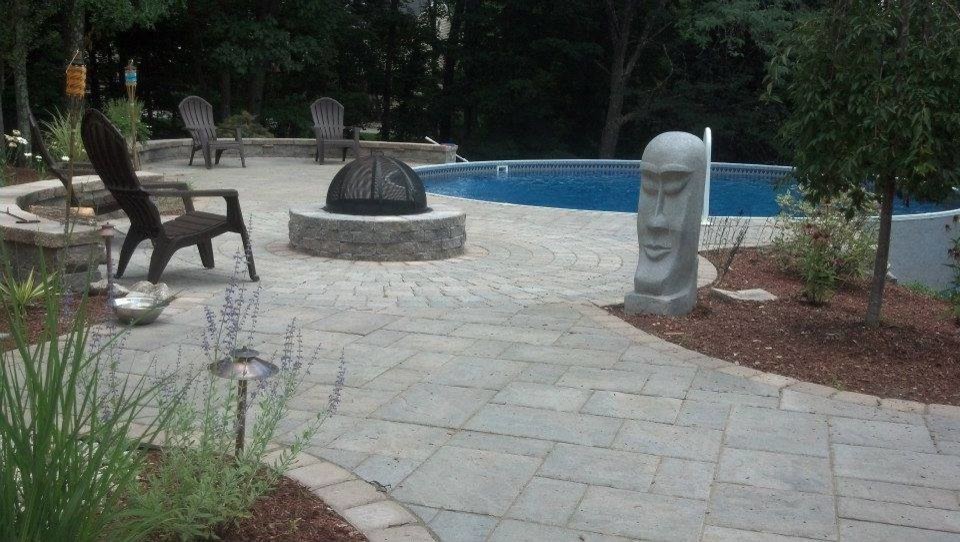 Photo of a small modern round aboveground pool in Manchester with concrete pavers.