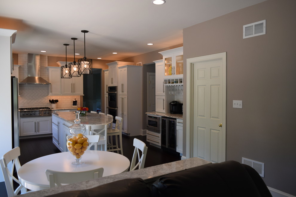 Inspiration for a huge transitional l-shaped dark wood floor eat-in kitchen remodel with an undermount sink, shaker cabinets, white cabinets, quartz countertops, white backsplash, subway tile backsplash, stainless steel appliances and an island