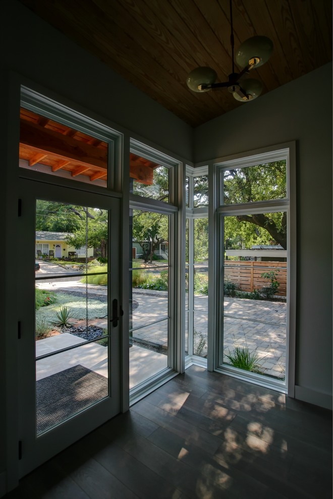 Photo of a modern foyer in Austin with white walls, medium hardwood floors, a double front door and a black front door.