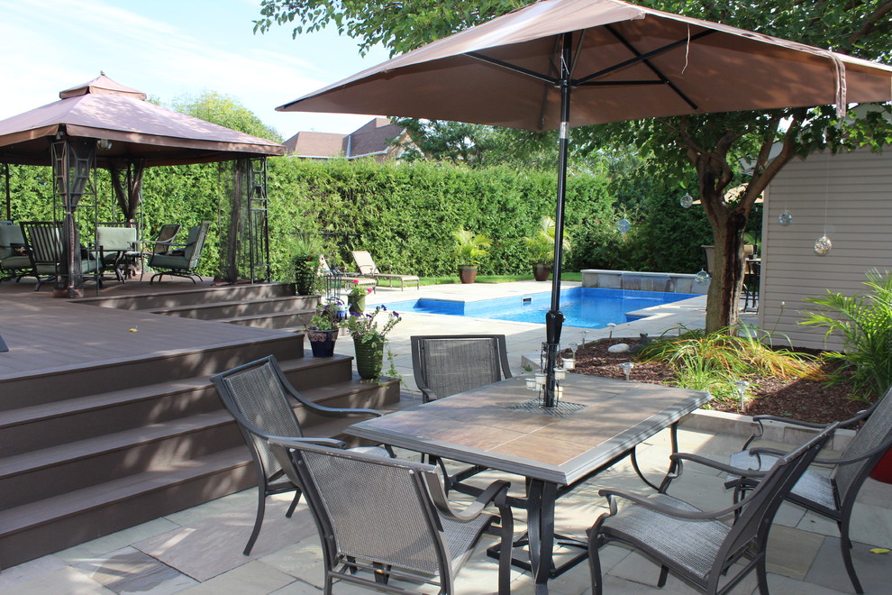 Large traditional backyard custom-shaped lap pool in Ottawa with a water feature and tile.