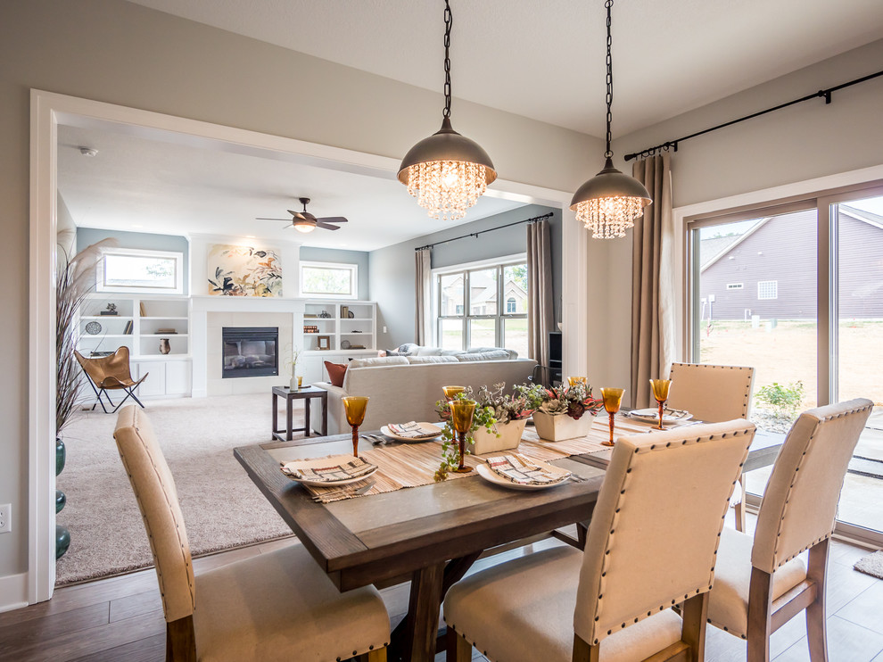 Inspiration for a mid-sized arts and crafts open plan dining in Other with grey walls, medium hardwood floors, a standard fireplace and a stone fireplace surround.
