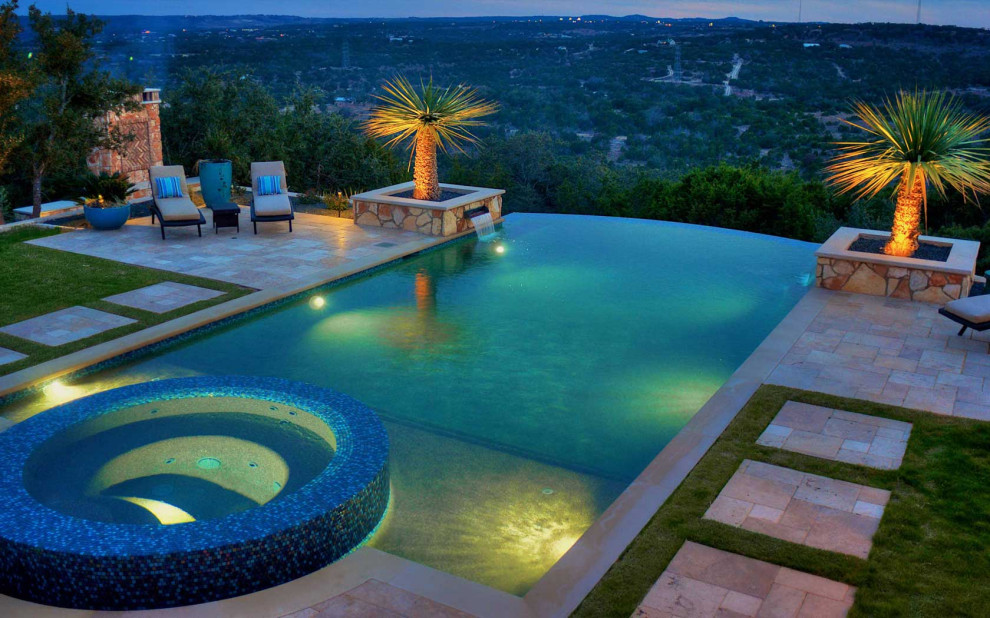 Tropical backyard infinity pool in Austin with a hot tub and tile.