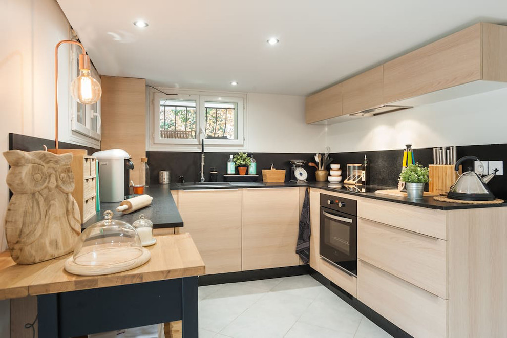 Design ideas for a mid-sized contemporary u-shaped open plan kitchen in Other with a single-bowl sink, beaded inset cabinets, light wood cabinets, laminate benchtops, black splashback, slate splashback, panelled appliances, ceramic floors, no island and white floor.