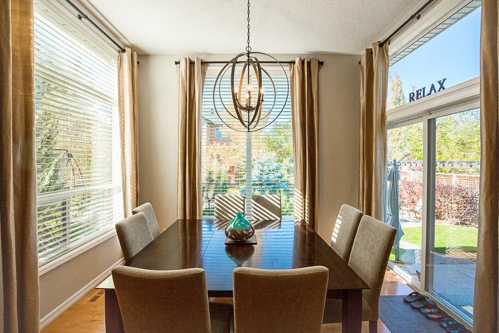 Photo of a mid-sized transitional open plan dining in Calgary with beige walls, light hardwood floors, no fireplace and brown floor.