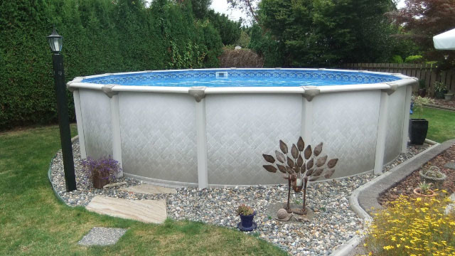 Backyard gravel and round aboveground pool photo
