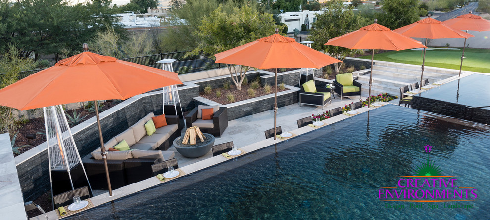Home design - huge modern backyard stamped concrete and custom-shaped infinity home design idea in Phoenix