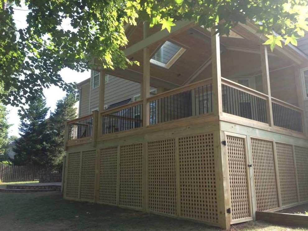Example of a mid-sized transitional backyard deck design in Raleigh with a roof extension