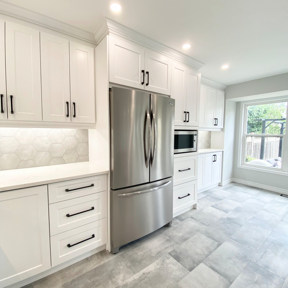 Open concept kitchen - large transitional u-shaped porcelain tile and gray floor open concept kitchen idea with an undermount sink, recessed-panel cabinets, white cabinets, quartzite countertops, gray backsplash, stainless steel appliances, a peninsula and white countertops