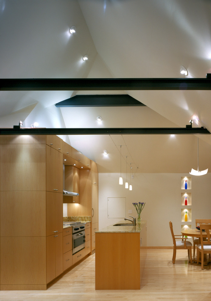 Contemporary galley eat-in kitchen in San Francisco with flat-panel cabinets, medium wood cabinets and stainless steel appliances.