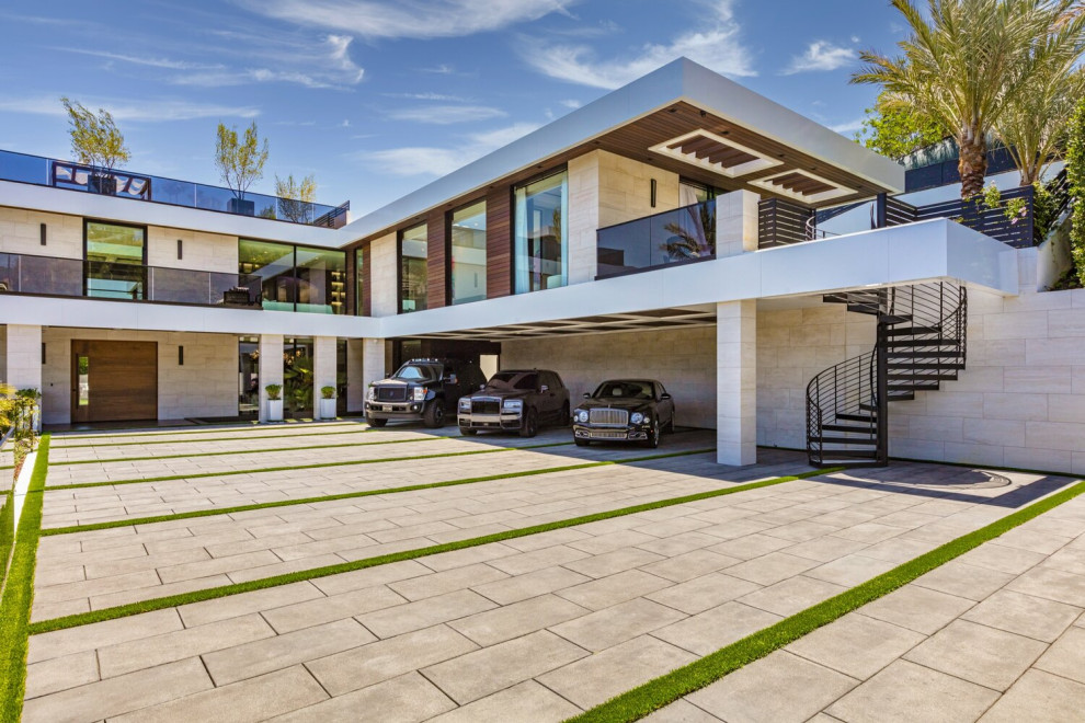 На фото: большой пристроенный гараж в стиле модернизм с навесом для автомобилей для трех машин