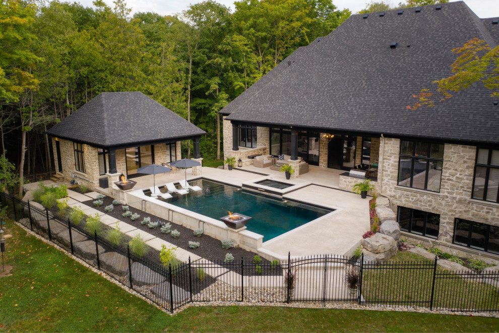Foto de piscina tradicional de tamaño medio rectangular en patio trasero con paisajismo de piscina y suelo de hormigón estampado