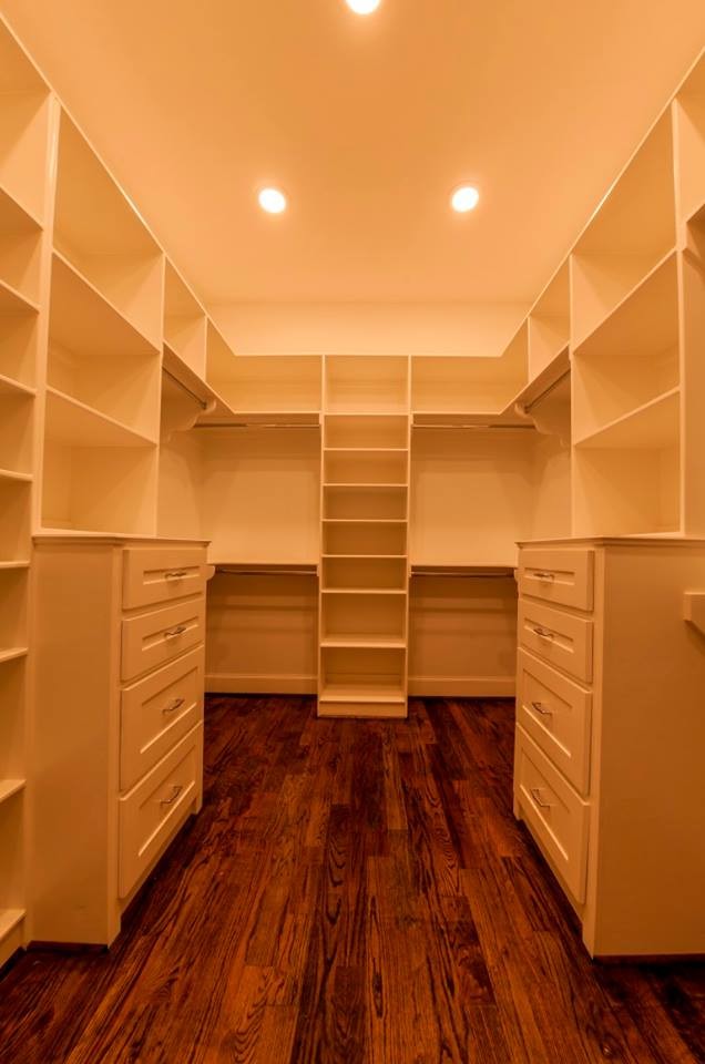 This is an example of a mid-sized transitional gender-neutral walk-in wardrobe in Houston with shaker cabinets, white cabinets and medium hardwood floors.