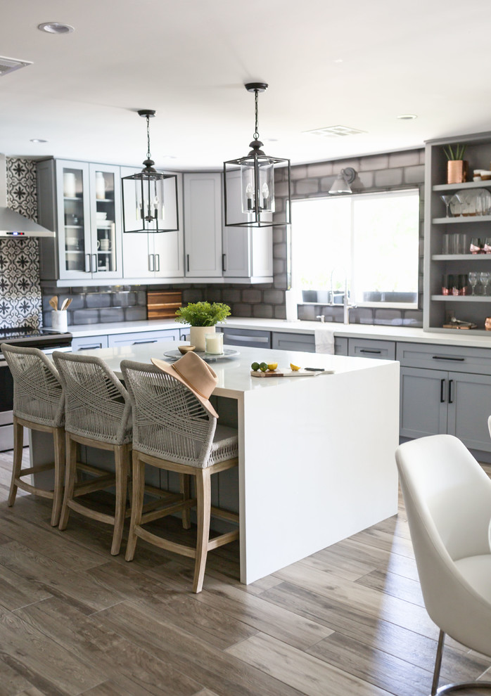 Mid-sized transitional u-shaped light wood floor and gray floor eat-in kitchen photo in Phoenix with an undermount sink, recessed-panel cabinets, gray cabinets, quartz countertops, multicolored backsplash, ceramic backsplash, stainless steel appliances, an island and white countertops