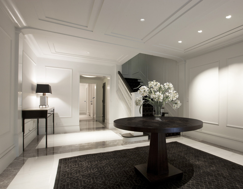 Photo of a contemporary foyer in Chicago with white walls and marble floors.