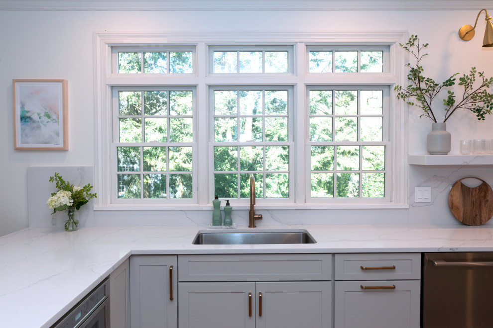 Large transitional l-shaped medium tone wood floor and brown floor eat-in kitchen photo in New York with an undermount sink, shaker cabinets, gray cabinets, quartz countertops, white backsplash, quartz backsplash, stainless steel appliances, an island and white countertops