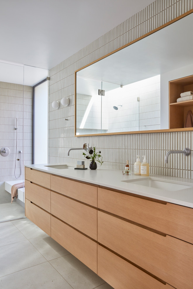 Photo of a large modern master bathroom in San Francisco with flat-panel cabinets, brown cabinets, a curbless shower, a one-piece toilet, white tile, ceramic tile, white walls, porcelain floors, an undermount sink, engineered quartz benchtops, beige floor, a hinged shower door, grey benchtops, a shower seat, a double vanity and a floating vanity.