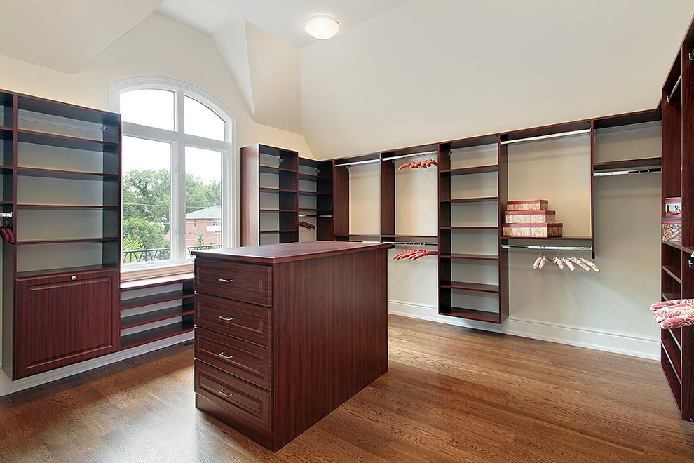 Photo of an expansive traditional women's walk-in wardrobe in Richmond with raised-panel cabinets, dark wood cabinets, dark hardwood floors and brown floor.