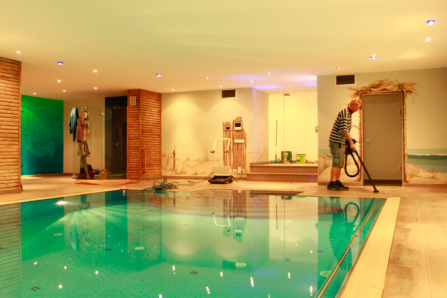 This is an example of a large mediterranean indoor rectangular pool in Munich with natural stone pavers.