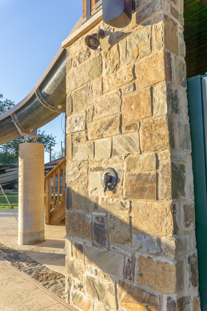 Example of a large mountain style backyard stone patio fountain design in Austin with a gazebo