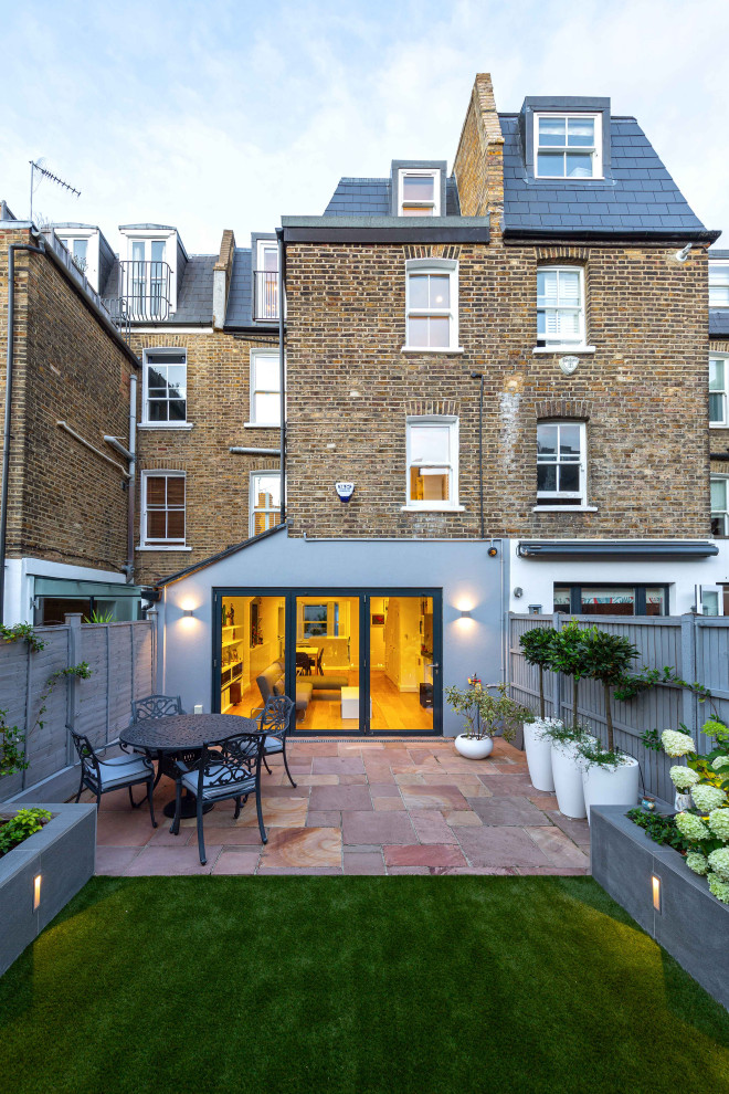 Geometrischer, Mittelgroßer, Halbschattiger Moderner Garten hinter dem Haus mit Blumenbeet, Natursteinplatten und Holzzaun in London