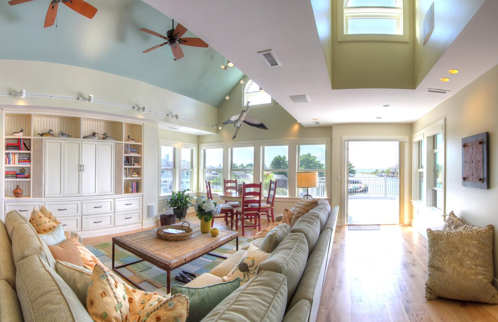 Photo of a large beach style family room with medium hardwood floors and a built-in media wall.