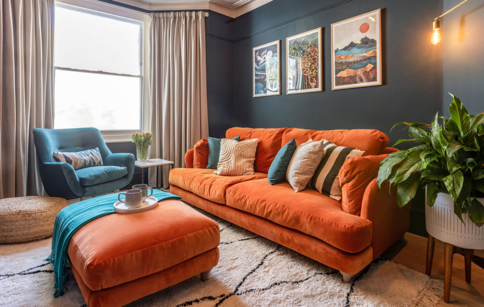 Idee per un soggiorno eclettico di medie dimensioni e chiuso con pareti blu, parquet chiaro, stufa a legna, cornice del camino in pietra, parete attrezzata e pavimento beige