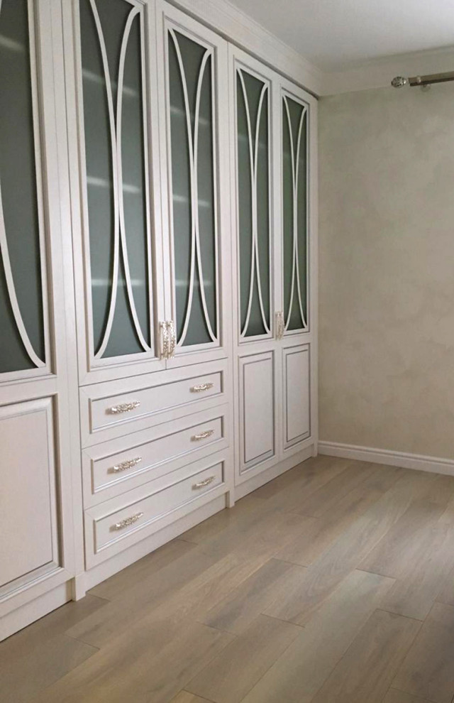 Cette image montre une chambre parentale blanche et bois vintage de taille moyenne avec un mur blanc, parquet clair, un sol beige et du papier peint.