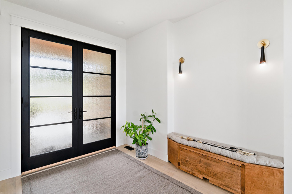 Diseño de puerta principal blanca moderna grande con paredes blancas, suelo de madera clara, puerta doble y puerta metalizada