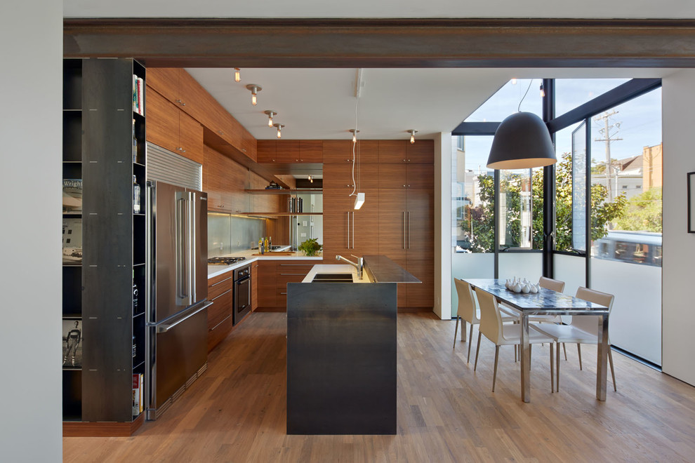 Inspiration for a small contemporary l-shaped open plan kitchen in San Francisco with flat-panel cabinets, dark wood cabinets, quartzite benchtops, metallic splashback, mirror splashback, stainless steel appliances, medium hardwood floors, with island and a double-bowl sink.
