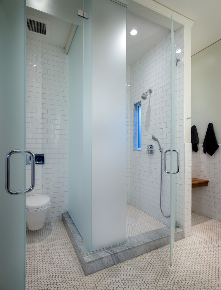 This is an example of a contemporary bathroom in San Francisco with a corner shower, a wall-mount toilet, white tile and subway tile.