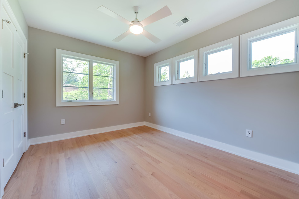 Mid-sized transitional bedroom in DC Metro with grey walls, light hardwood floors, no fireplace and beige floor.