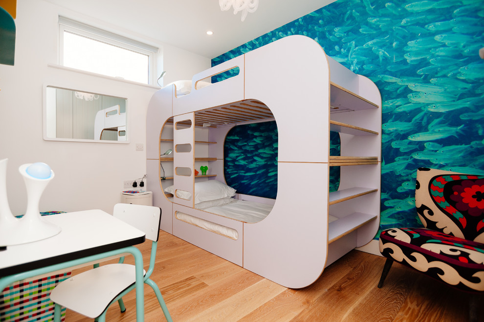 Contemporary gender-neutral kids' bedroom in Cornwall with medium hardwood floors and multi-coloured walls for kids 4-10 years old.