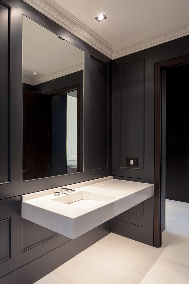 Large modern powder room in Toronto with an integrated sink, solid surface benchtops, white tile, black walls, marble floors and white floor.