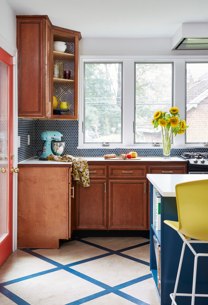 ニューヨークにある高級な中くらいなエクレクティックスタイルのおしゃれなキッチン (レイズドパネル扉のキャビネット、青いキャビネット、クオーツストーンカウンター、白いキッチンパネル、クオーツストーンのキッチンパネル、シルバーの調理設備、コルクフローリング、マルチカラーの床、白いキッチンカウンター) の写真