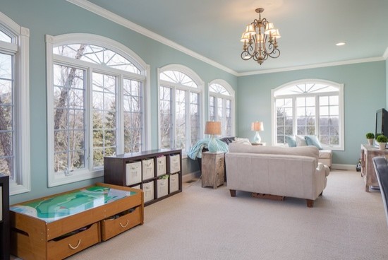 This is an example of a large transitional enclosed family room in New York with blue walls, carpet, a game room, no fireplace and a freestanding tv.