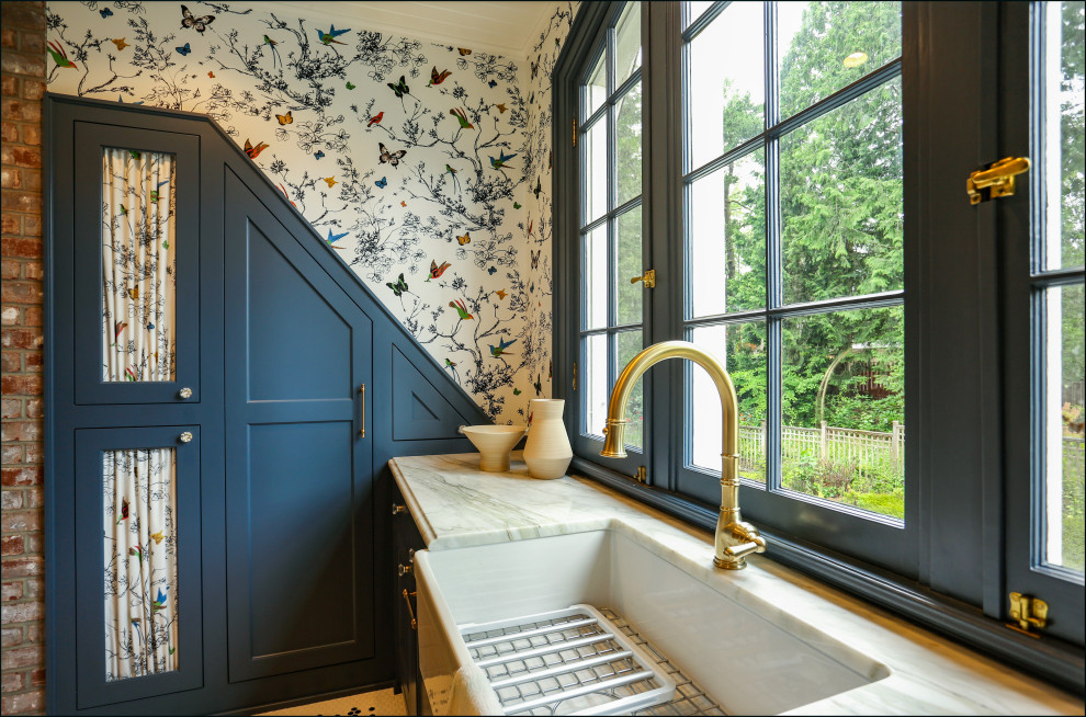 Inspiration for a large traditional u-shaped dedicated laundry room in Portland with an undermount sink, shaker cabinets, blue cabinets, marble benchtops, multi-coloured walls, porcelain floors, a side-by-side washer and dryer, multi-coloured floor, white benchtop, timber and wallpaper.