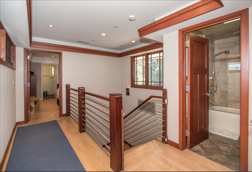 This is an example of a mid-sized midcentury hallway in San Francisco with white walls, light hardwood floors and brown floor.